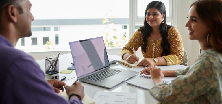 Businessman presenting ideas to smiling coworkers in meeting